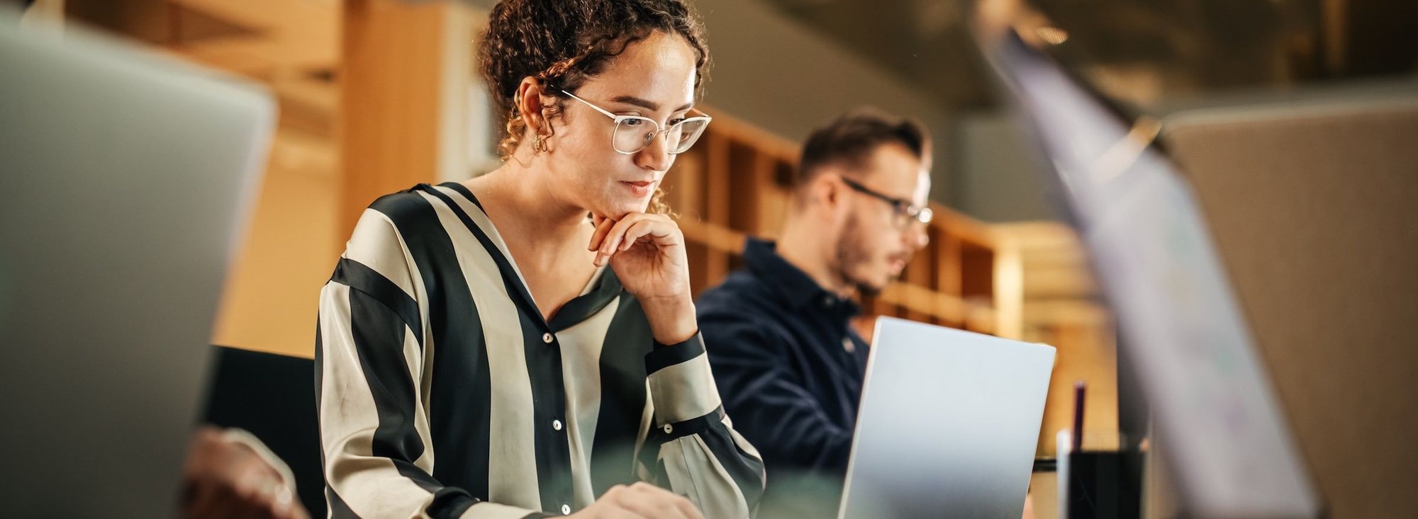 woman looking at analytics on one of a row of laptops